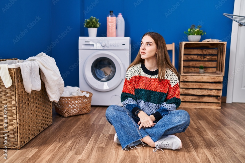Young hispanic girl doing laundry looking to side, relax profile pose with natural face with confident smile. Young hispanic girl doing laundry looking to side, relax profile pose with natural face with confident smile.