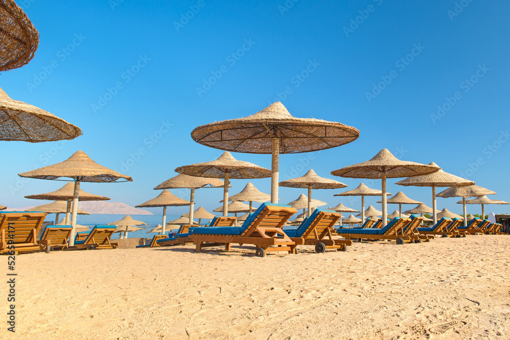 Fototapeta premium Beach with sunbeds, umbrellas and yellow sand.