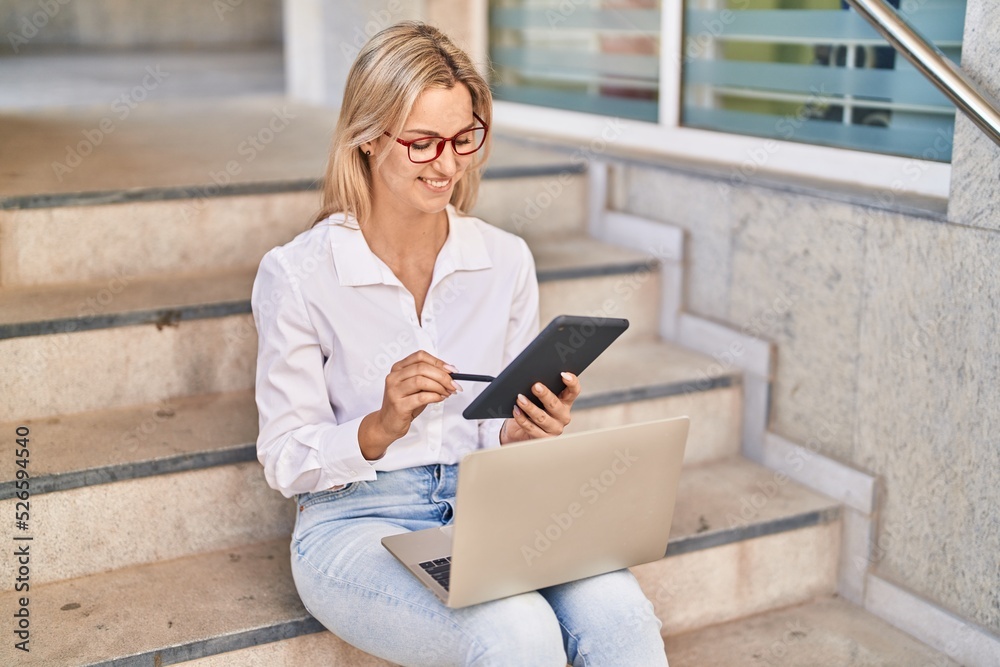 Young blonde woman using laptop and touchpad at street Young blonde woman using laptop and touchpad at street