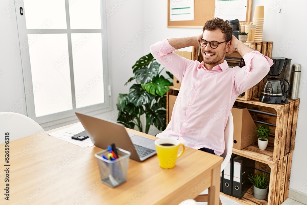 Young hispanic man relaxed with hands on head working at office Young hispanic man relaxed with hands on head working at office