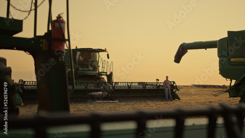 Fotografie Farming machinery golden sunset field silhouette
