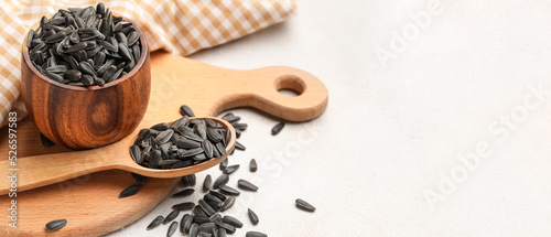 Bowl and spoon with sunflower seeds on white background with space for text