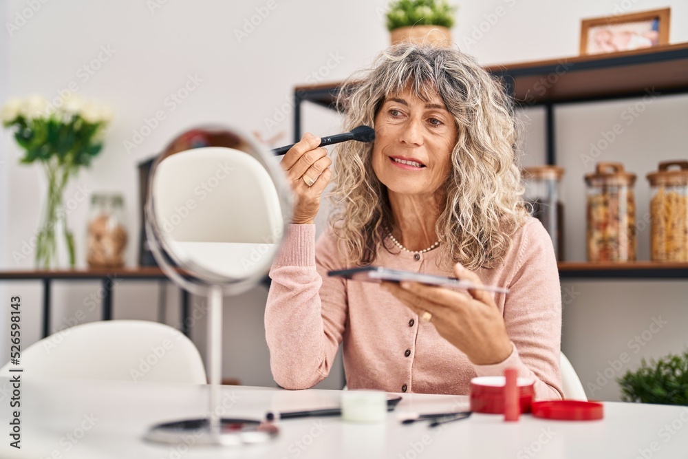 Middle age woman smiling confident applying makeup at home Middle age woman smiling confident applying makeup at home