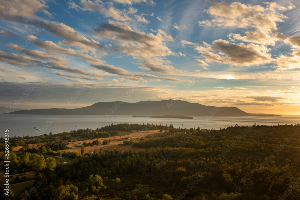 Sunset View of Orcas Island, Washington. A beautiful aerial look at a summer cloudscape over Orcas island in the San Juan Islands and the Salish Sea as seen from Lummi Island.