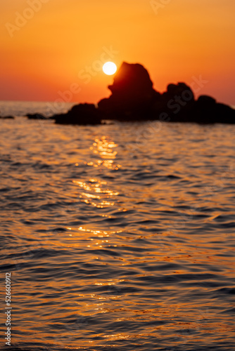 Beautiful view of orange sunset seascape with rocks in Italy. Tropical colourful sunrise landscape. Nature landscape. Tropical island coast