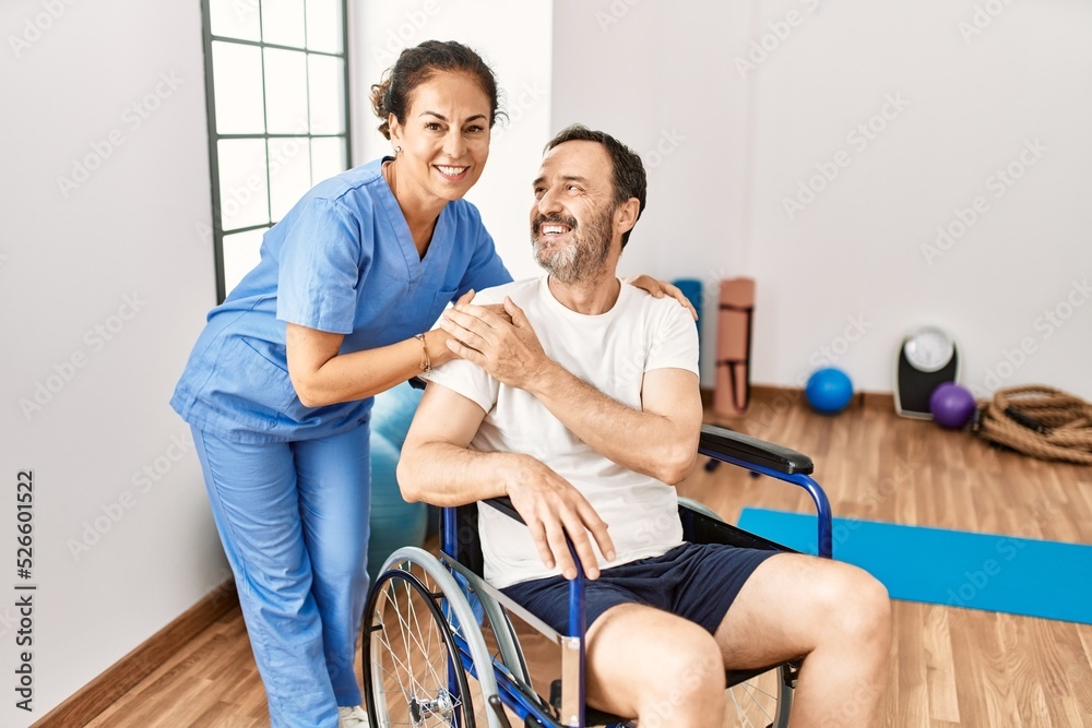 Middle age man and woman smiling confident having physiotherapy session at physiotherapy clinic Middle age man and woman smiling confident having physiotherapy session at physiotherapy clinic