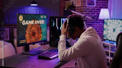 Fotografia Gamer feeling unhappy after losing difficult level in online space shooter on gaming pc at home