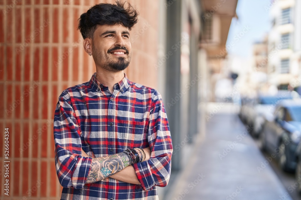 Young hispanic man smiling confident standing with arms crossed gesture at street