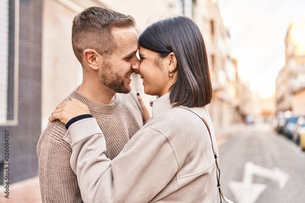 Man and woman couple smiling confident hugging each other standing at street