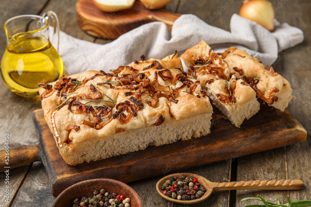 Board of tasty Italian focaccia with roasted onion on wooden table, closeup Board of tasty Italian focaccia with roasted onion on wooden table, closeup