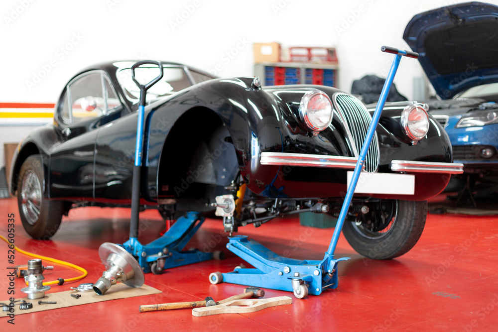 Antique automobile being repaired in the mechanic workshop. Overhaul and restoration of classic cars.