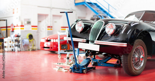 Panoramic view of the interior of a garage. Classic car being repaired. Space for text. photo