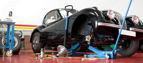 Panoramic view of antique automobile being repaired in the mechanic workshop. Maintenance and restoration of classic cars.