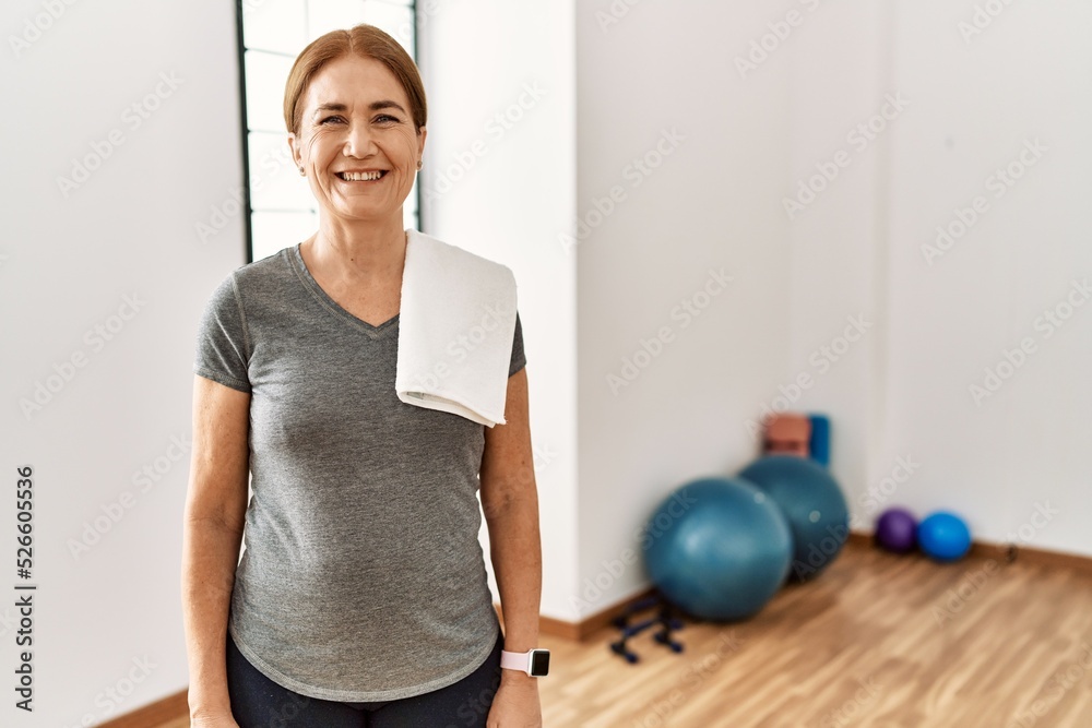 Middle age woman wearing sporty look training at the gym room with a happy and cool smile on face. lucky person. Middle age woman wearing sporty look training at the gym room with a happy and cool smile on face. lucky person.