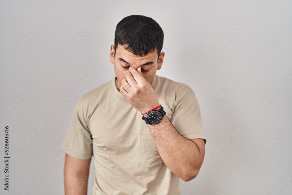 Young arab man wearing casual t shirt tired rubbing nose and eyes feeling fatigue and headache. stress and frustration concept.