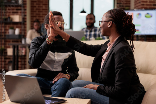 Obraz na plátně Team of colleagues giving highfive in office, doing work collaboration on business presentation and data report