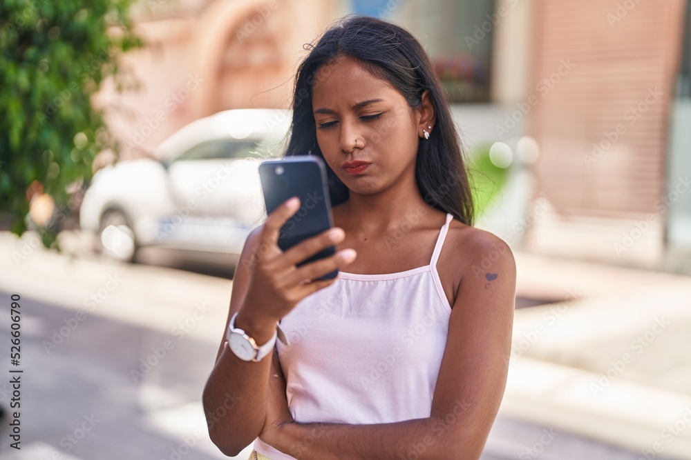 Young beautiful woman using smartphone with relaxed expression at street Young beautiful woman using smartphone with relaxed expression at street