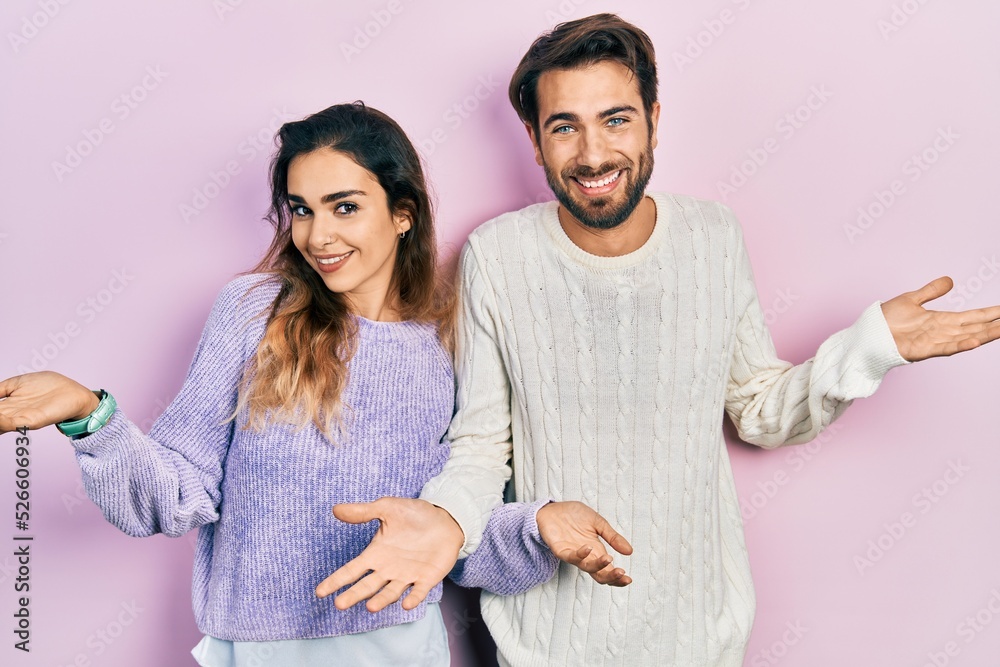 Young hispanic couple wearing casual clothes smiling showing both hands open palms, presenting and advertising comparison and balance