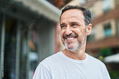 Middle age man smiling confident looking to the side at street