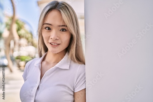 Young chinese girl smiling happy standing at the city. Free Download Young chinese girl smiling happy standing at the city. - GFXLoad