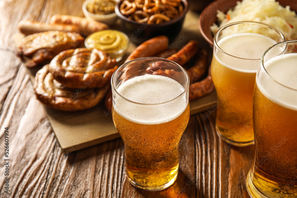 Mugs of fresh beer and traditional food on wooden background, closeup. Oktoberfest celebration Mugs of fresh beer and traditional food on wooden background, closeup. Oktoberfest celebration