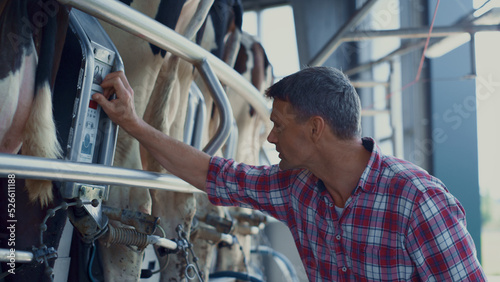 Foto Farmer checking milking technological system in dairy manufacture close up