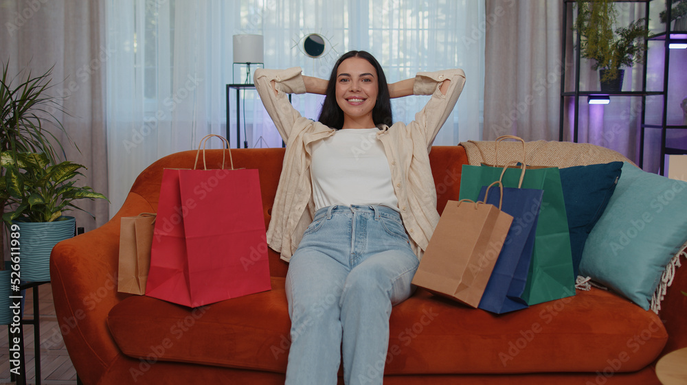 Obraz premium Portrait of caucasian adult girl happy shopaholic consumer came back home after shopping sale with bags. Young woman satisfied received parcels from online order at modern home apartment living room