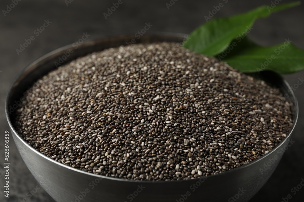 Metal bowl with chia seeds on grey table, closeup Metal bowl with chia seeds on grey table, closeup