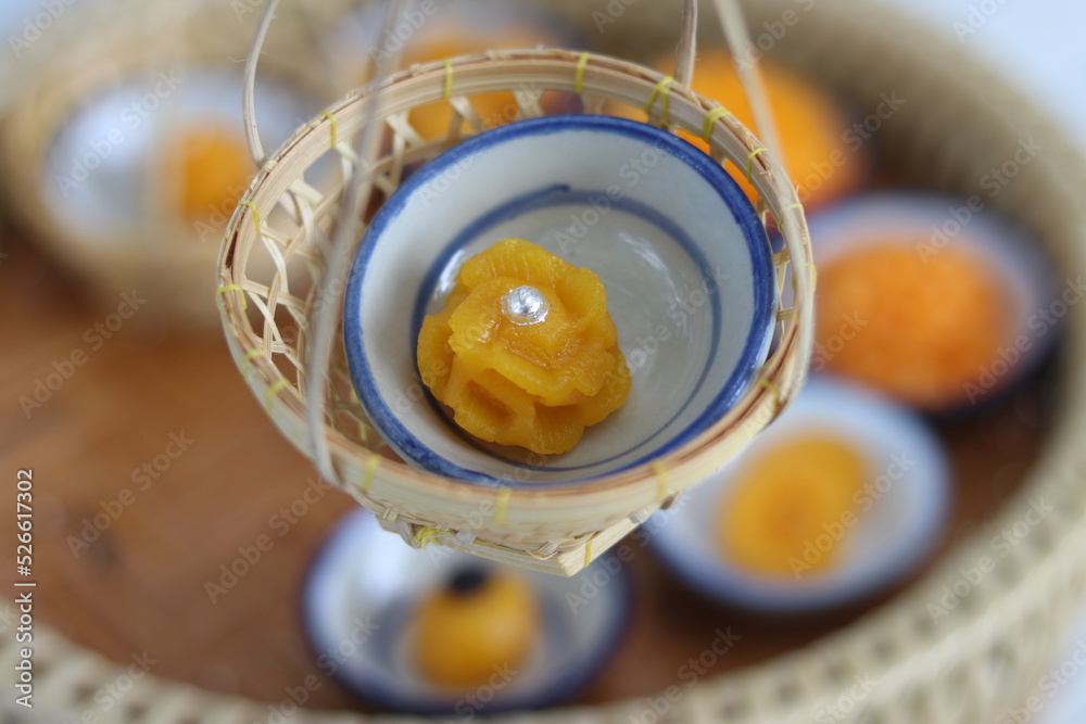 Hand holding Sweet Golden Cake recipe topping with sprinkles (Kanom Thong Ake in Thai language). Sweet traditional Thai dessert made of wheat flour, egg yolks, coconut milk and sugar. Hand holding Sweet Golden Cake recipe topping with sprinkles (Kanom Thong Ake in Thai language). Sweet traditional Thai dessert made of wheat flour, egg yolks, coconut milk and sugar.