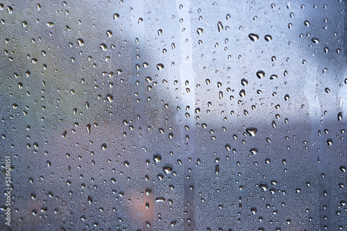 Print op canvas dew drops over glass window a raining day.