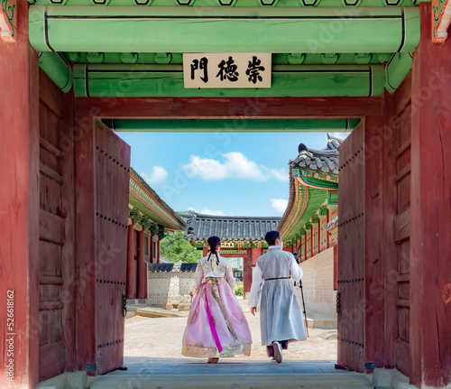 Photography Couple wearing traditional Korean clothing hanbok by a colorful wooden temple en