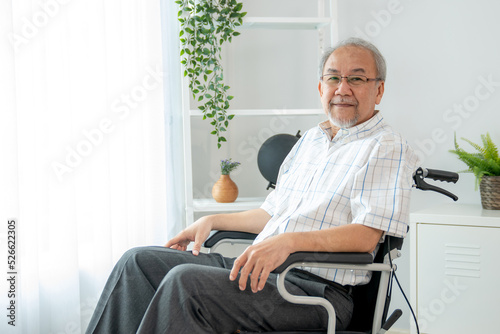 Photographie Portrait of an elderly man in a wheelchair alone with himself at home but contented with his lot in life