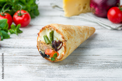 pizza in a cone with tuna and vegetables on white wooden table