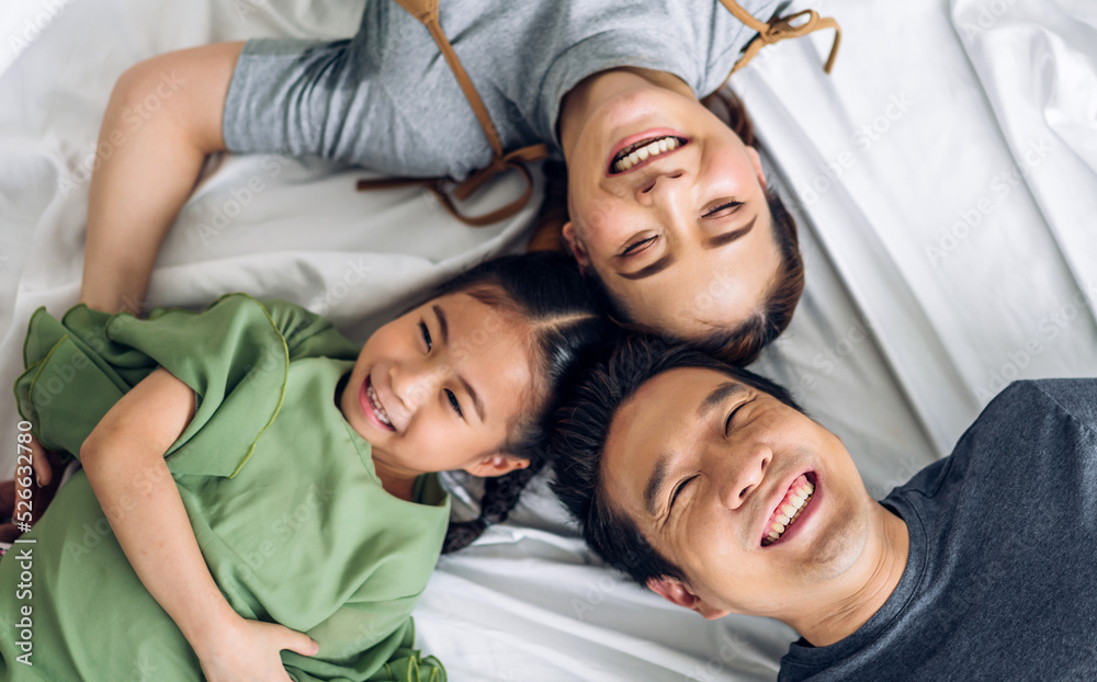 Portrait of enjoy happy love asian family father and mother holding hug cute little asian girl child smiling play and having fun moments good time in at home