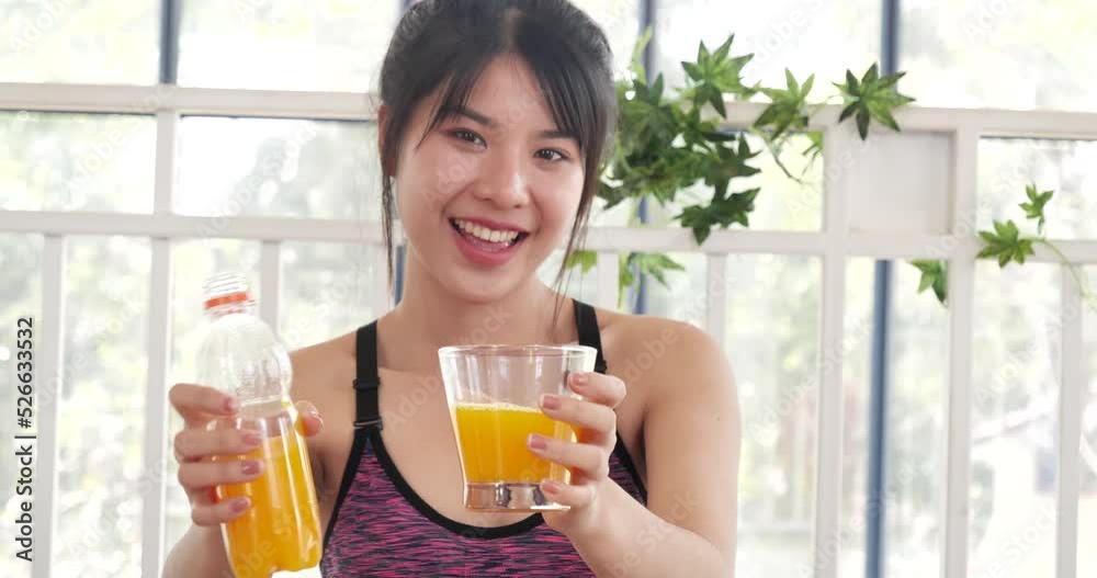 Women hands holding cold orange juice fresh fruit cool drinking. Asian women smile laugh look at camera health care home fitness lifestyle. Beautiful female pouring orange juice from cocktail bottle Women hands holding cold orange juice fresh fruit cool drinking. Asian women smile laugh look at camera health care home fitness lifestyle. Beautiful female pouring orange juice from cocktail bottle