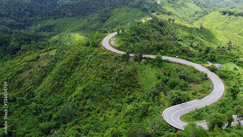 A winding path for traveling in the mountains with forests and trees.