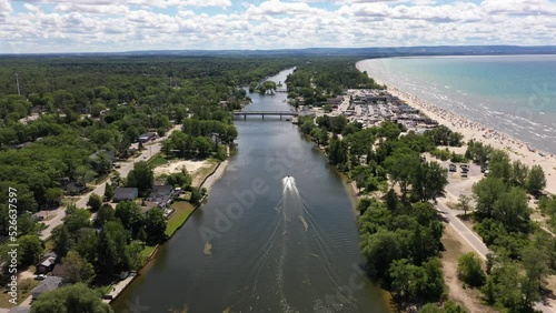 Wasaga beach jet skies going by boat yard stores and beach shore in view  photo