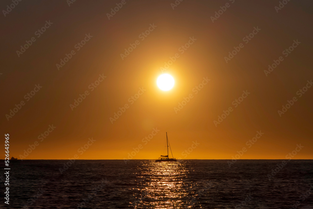 Sea yachts against the background of the sun reflected in the waves