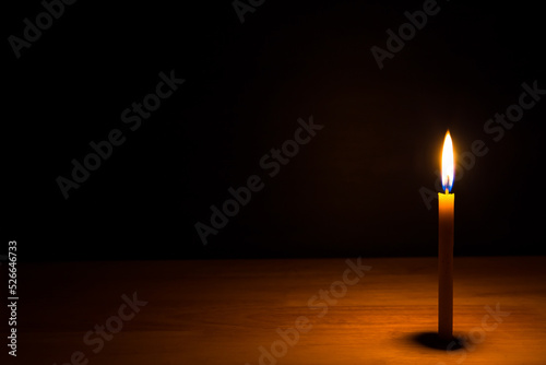 Candle light on the wooden table in the dark night. picture for art work design or add text message.