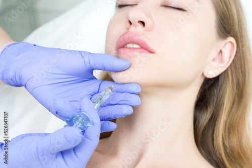 The cosmetologist makes anti-aging injections against wrinkles on the chin  cheeks and neck. Women s aesthetic cosmetology.