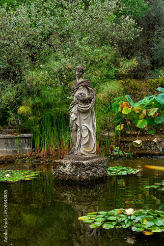 Statue of a woman in a Pool with water lily in the French garden. Jardin Serre de la Madone  with rare plantings. Summer. Menton  France.