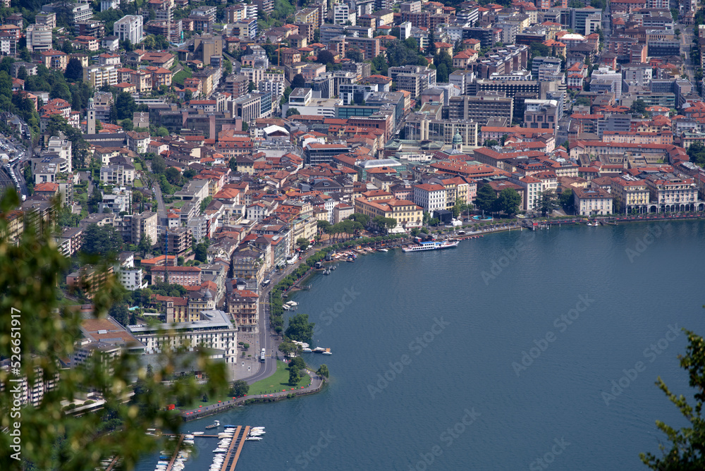 Fototapeta premium Aerial view of City of Lugano seen from local mountain San Salvatore on a sunny summer day. Photo taken July 4th, 2022, Lugano, Switzerland.