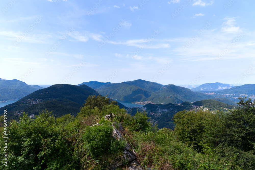 Scenic landscape with mountain panorama and Lake Lugano seen from local mountain San Salvatore at City of Lugano on a cloudy summer day. Photo taken July 4th, 2022, Lugano, Switzerland.