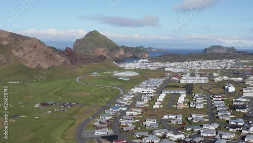 Heimaey nordic island with small remote town and green golf course, aerial photo