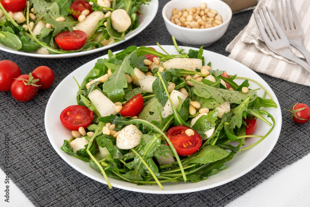 Fresh salad with arugula, melon, tomato, mozzarella cheese and pine nuts for healthy lunch. Fresh salad with arugula, melon, tomato, mozzarella cheese and pine nuts for healthy lunch.