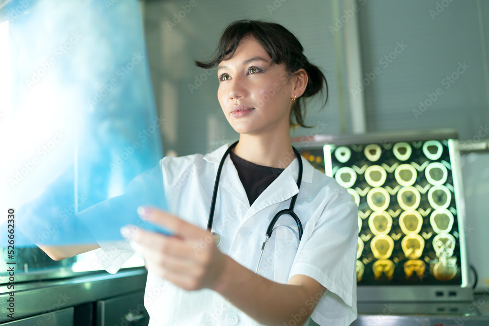 Team of doctors discuss results of X-Ray or MRI scan of patient's brain in medicine office of clinic Team of doctors discuss results of X-Ray or MRI scan of patient's brain in medicine office of clinic