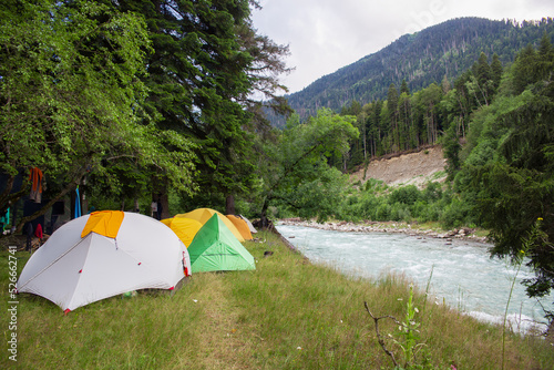 Tourist tents stand on the banks of the river.