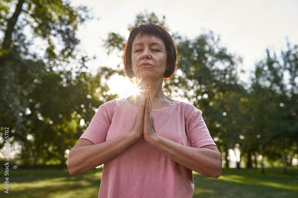 Mature woman practice yoga and meditate in park Mature woman practice yoga and meditate in park