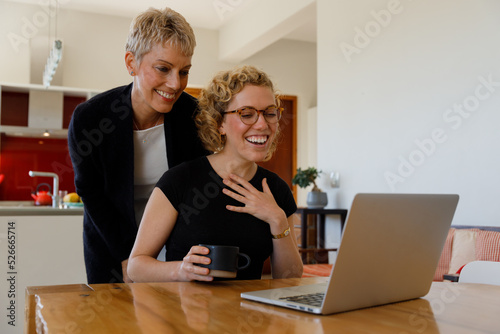 Happy daughter and mother video calling over laptop at home © Timm Creative