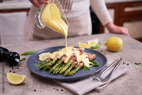 Healthy food - Asparagus wrapped with bacon and spices on a plate photo